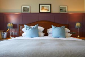 斯卡伯勒The Grainary Boutique Hotel的一间卧室配有一张带蓝色枕头的大床