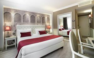 维罗纳Hotel Giberti & Spa的卧室配有带红色枕头的大型白色床