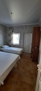 凯瓦尼Пограничная 8的一间卧室设有两张床、一个窗口和一扇门