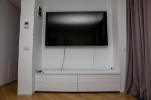 布加勒斯特Novum Aparthotel的白色墙壁上的平面电视