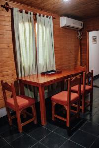 卡法亚特Cabañas y Hostal Las Marias的一张带两把椅子的木桌和一张带窗户的桌子