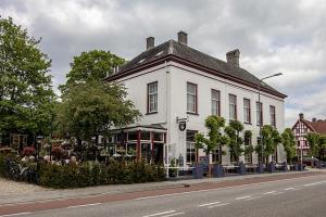 德斯泰赫Hotellerie Het Wapen Van Athlone的街道边的白色建筑
