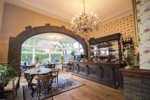 德斯泰赫Hotellerie Het Wapen Van Athlone的一间带拱门和桌椅的用餐室