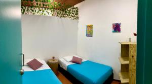 波哥大Hostal Macondo Bogotá的一间客房内配有两张床的房间