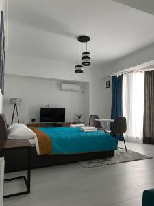 马马亚Solid Luxury Studio的一间卧室配有一张床、一张书桌和一台电视