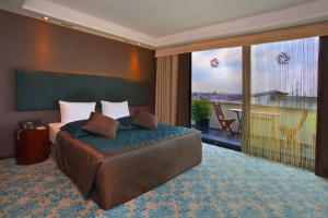伊斯坦布尔Pera Tulip Hotel & Spa - Taksim Pera的一间带大床的卧室和一个阳台