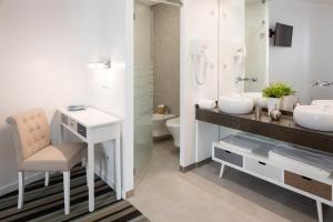 里斯本Marino Lisboa Boutique Guest House的一间带两个盥洗盆、一张书桌和一个卫生间的浴室。
