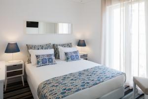 里斯本Marino Lisboa Boutique Guest House的一间卧室配有一张带蓝白色枕头的大床