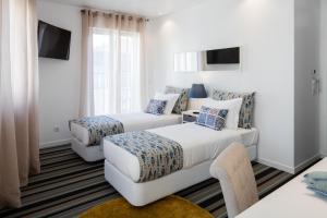 里斯本Marino Lisboa Boutique Guest House的酒店客房,设有两张床和一张沙发