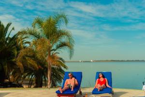 特尔马斯德里奥翁多玛丽娜德尔法鲁度假酒店的坐在沙滩椅上的男人和女人