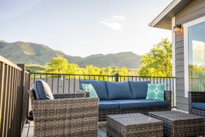 高尔顿Modern Golden Cottage with Incredible Mountain View!的一个带蓝色沙发和藤椅的庭院