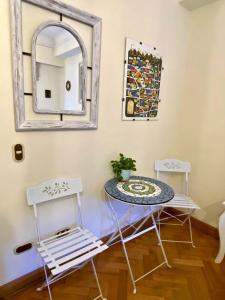 圣地亚哥Bed & Breakfast Lastarria的一张桌子和两把椅子,位于一个带镜子的房间