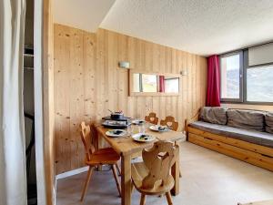 里蒙纽耶Appartement Les Menuires, 2 pièces, 4 personnes - FR-1-344-969的木制客房配有桌子和沙发