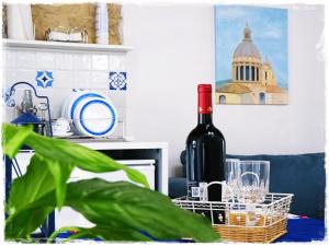 拉古萨L'arco delle Commari的一瓶葡萄酒和一株植物坐在桌子上