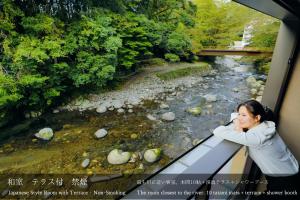 伊豆龙田日式旅馆的拍着河面照片的女人