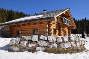 拉赫塔尔Schönberghütte的雪地中的小木屋,带有石墙