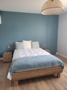 MoslesLa Mosloise的一间卧室设有一张蓝色墙壁的大床