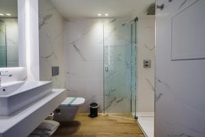 科马鲁加布里斯玛套房酒店的一间带卫生间和玻璃淋浴间的浴室