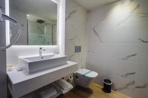 科马鲁加布里斯玛套房酒店的白色的浴室设有水槽和卫生间。