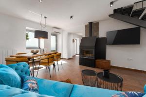 拉宾CASA GIUSEPPE Luxury house with an amazing view的客厅配有蓝色的沙发和桌子