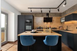 拉宾CASA GIUSEPPE Luxury house with an amazing view的厨房配有2把蓝色椅子,位于柜台