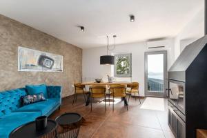 拉宾CASA GIUSEPPE Luxury house with an amazing view的客厅配有蓝色的沙发和桌子