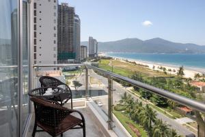 岘港岘港公河大酒店的阳台配有两把椅子,享有海滩美景