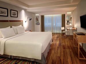 库塔库塔海滩遗产酒店 - 由雅高酒店集团管理的酒店客房设有一张大床和一台电视。