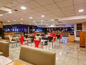 里约热内卢宜必思RJ新星美国酒店的一间带桌椅的用餐室和一间餐厅