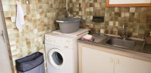 Caux-et-SauzensGîte indépendant的小厨房配有洗衣机和水槽