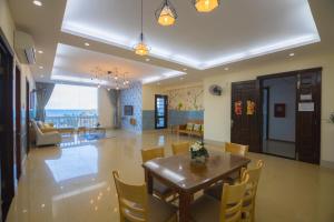 头顿Vung tau seaview apartment 2 - Nhavungtauorg - Son Thinh2 apartment - Oasky lounge的用餐室以及带桌椅的起居室。