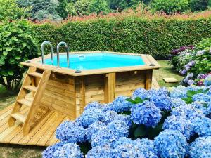 比亚里茨Villa de charme parc fleuri, arboré et piscine à BIARRITZ的花草花园中的木制热水浴池