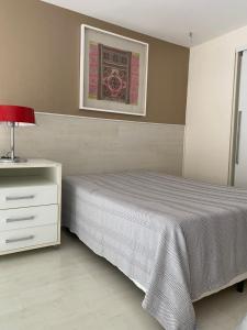 萨尔瓦多Vitoria Loft 403的一间卧室配有一张床、梳妆台和一张照片