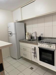 萨尔瓦多Vitoria Loft 403的厨房配有白色冰箱和炉灶。