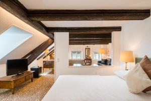 穆尔滕穆尔滕霍夫＆克朗酒店的一间卧室配有一张床,并在一间客房内配有电视。