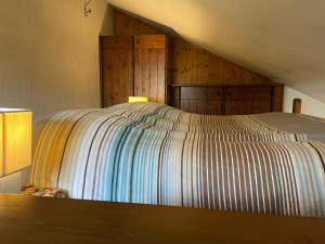 托尔诺Gli appartamenti della Fra的一张带条纹床罩的床