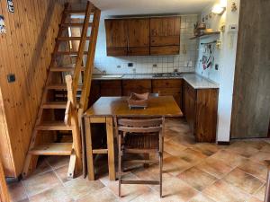 托尔诺Gli appartamenti della Fra的厨房设有木桌和木楼梯。