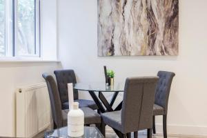 滨海绍森德Modern apartment -Perfect for Contractors & Families By Luxiety Stays Serviced Accommodation Southend on Sea的一间带桌椅和绘画的用餐室