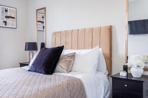 滨海绍森德Modern apartment -Perfect for Contractors & Families By Luxiety Stays Serviced Accommodation Southend on Sea的一间卧室配有带枕头和镜子的床