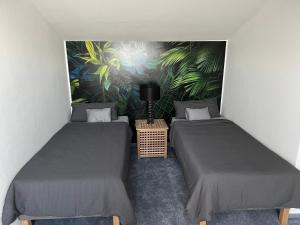 NeckarwestheimLoft Wohnung Appartement auf 2 Etagen, Nähe Neckar的壁画客房内的两张单人床