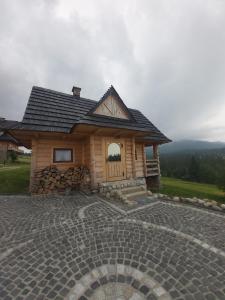 希切玛尔Domki na wzgórzu的小屋前方设有石质天井。