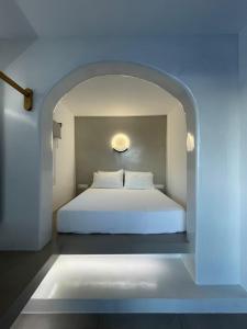 迈洛波塔斯安娜玛丽亚之家酒店的拱门上的卧室配有白色的床