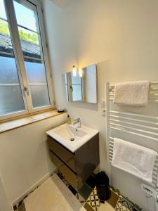 穆兰Appartement cosy Centre ville的白色的浴室设有水槽和窗户。