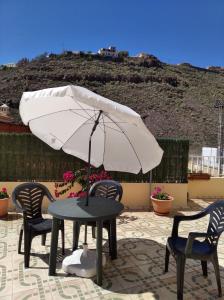 圣地亚哥海滩马特尔公寓的庭院内桌椅和遮阳伞