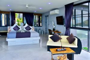 苏梅岛Paradise Villa Elysium的一间卧室配有一张床、一张沙发和窗户。