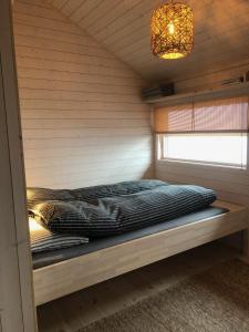 弗洛Hytte på Sørbølfjellet的小屋内的一张床位,配有窗户和吊灯
