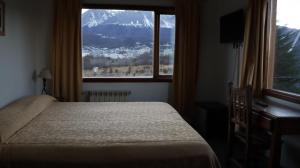 乌斯怀亚OIKOS的一间卧室配有一张床和一个享有山景的窗户