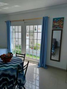 圣安德烈斯Holiday Loft Suite Apartamento的一间配备有桌子和蓝色窗帘的用餐室