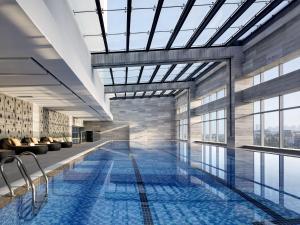 厦门厦门朗豪酒店（近高铁站 毗邻万达银泰五缘湾）的一座带玻璃天花板的建筑中的游泳池