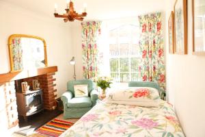 希灵登Swan Guest House LONDON - HEATHROW的一间卧室配有一张床、两把椅子和一个窗户